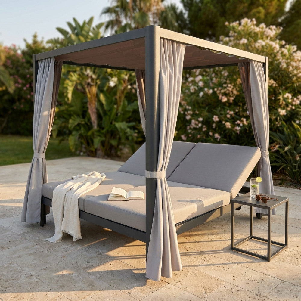 Vista frontale del gazebo letto matrimoniale da esterno con cuscini grigi e tavolino.