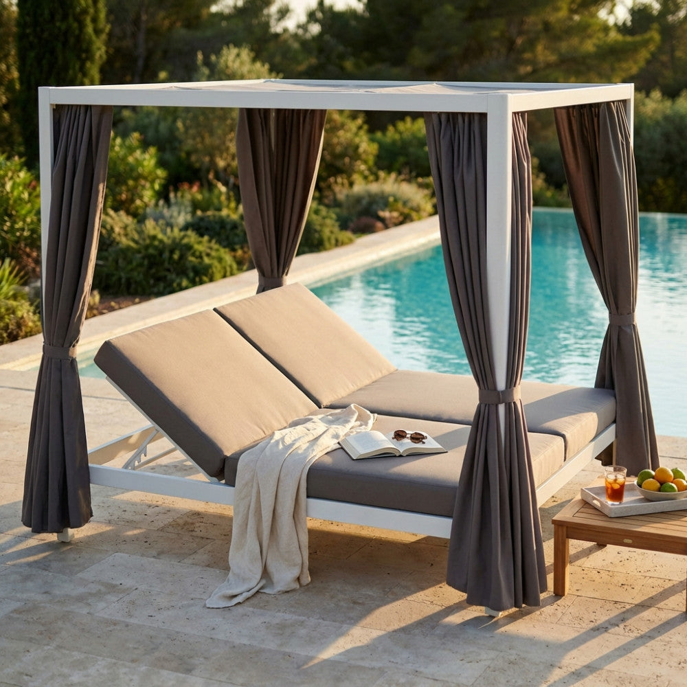 Gazebo Letto Timbuktu in alluminio bianco a bordo piscina, con tende grigie aperte e lettino doppio reclinato.
