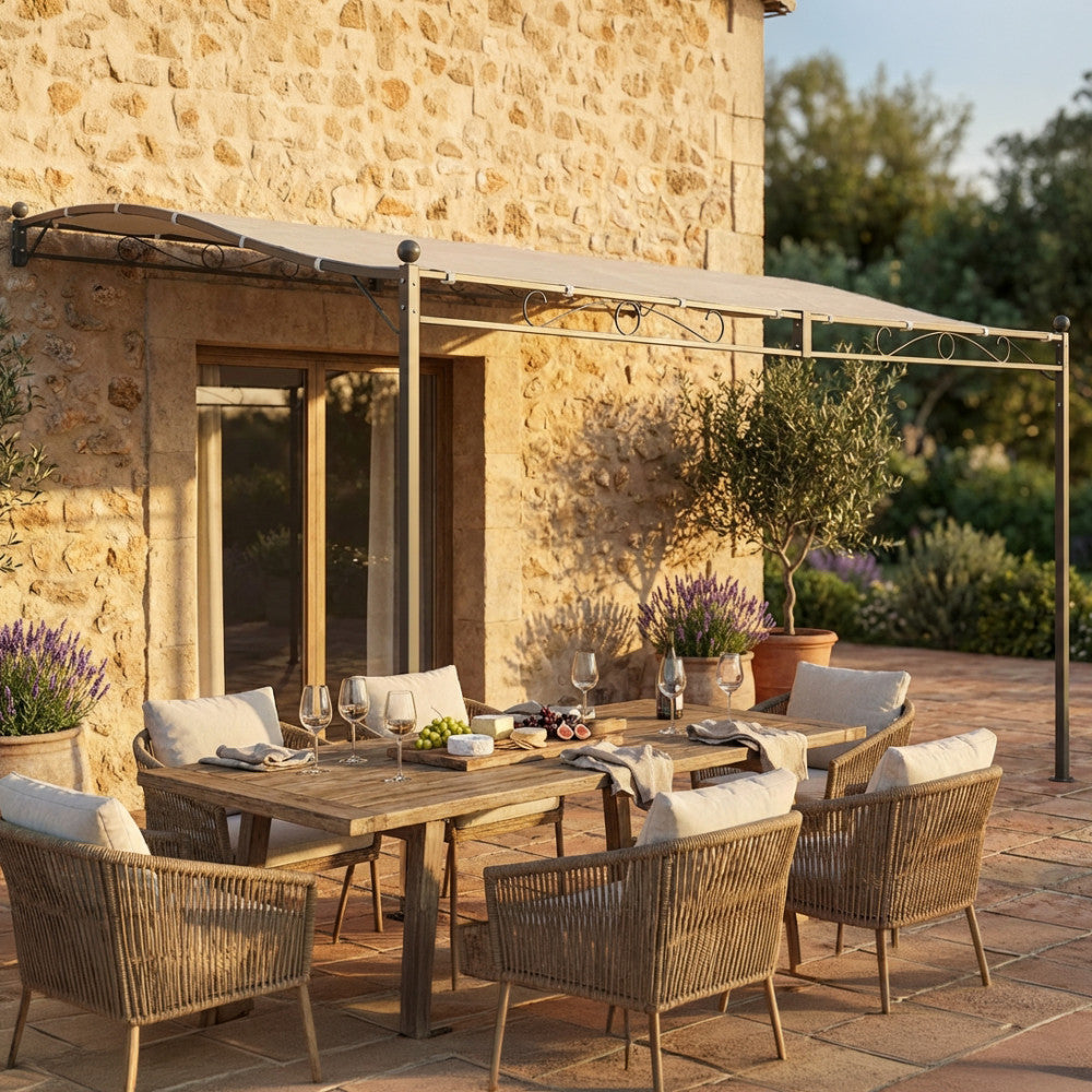 Gazebo pergola addossato in acciaio e poliestere, che ombreggia un grande tavolo da pranzo in legno con sedie intrecciate.