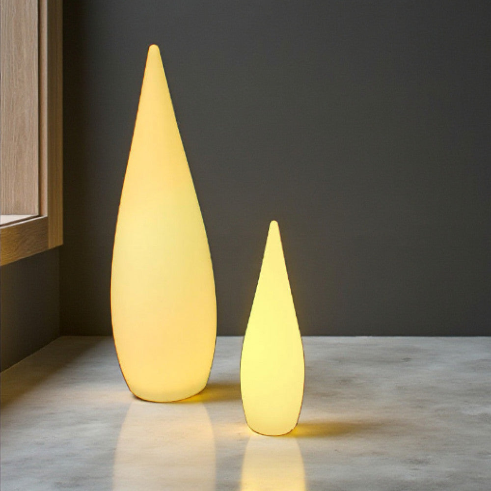 Coppia di lampade da terra dal design a goccia in polietilene giallo collocate su un pavimento in cemento in un interno minimalista.