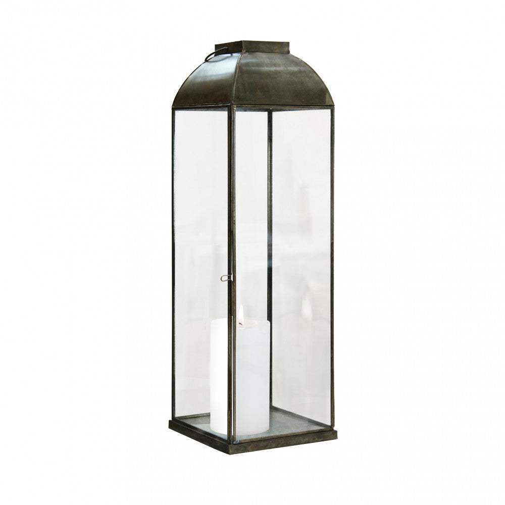 Lanterna Karrie Media accesa con candela, usata come luce d'ambiente in un giardino