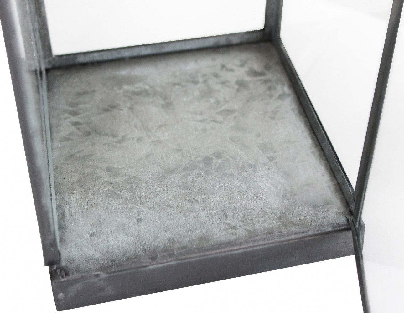 Dettagli interno Lanterna Kaylin Grande in metallo grigio in un ambiente con piante decorative.