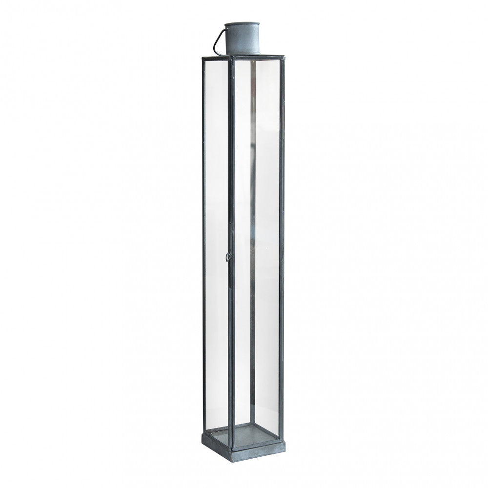 Lanterna Kaylin Grande in metallo grigio in un ambiente con piante decorative.