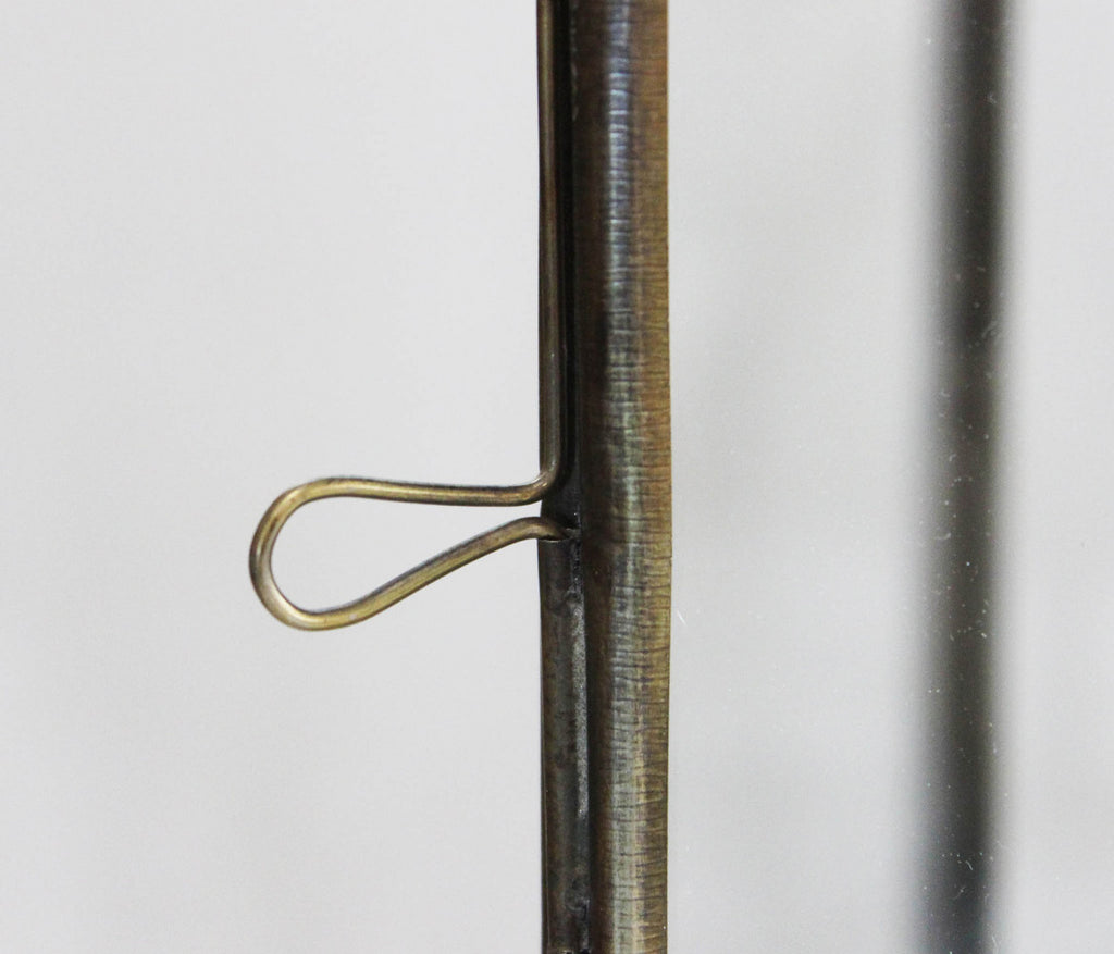 Dettaglio del gancio di chiusura in metallo curvato, che sottolinea la precisione artigianale della struttura.