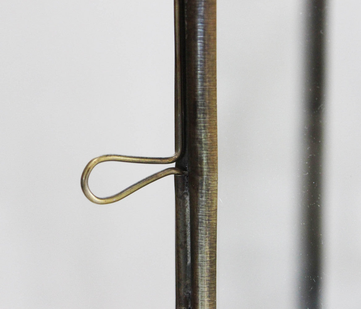 Dettaglio del gancio di chiusura in metallo curvato, che sottolinea la precisione artigianale della struttura.