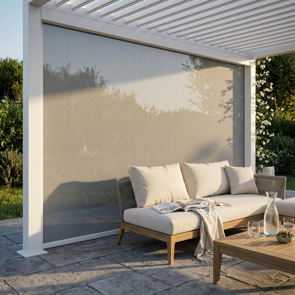 Pannello laterale in textilene bianco abbassato su una pergola bioclimatica, affiancato da un divano outdoor.