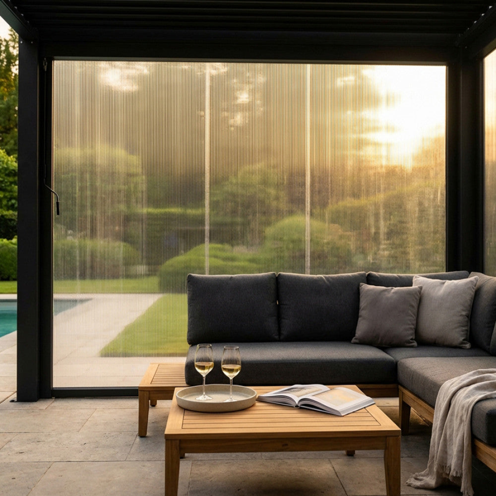 Vista frontale del Pannello Laterale GA802123-DGRE in PVC installato su una pergola bioclimatica, con un salotto outdoor elegante in primo piano.