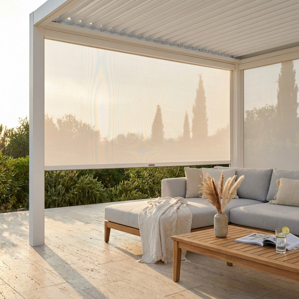 Pannello laterale in textilene bianco completamente abbassato su una pergola moderna, che ombreggia un divano outdoor con tavolino in teak.