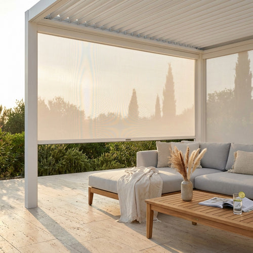 Pannello laterale in textilene bianco completamente abbassato su una pergola moderna, che ombreggia un divano outdoor con tavolino in teak.