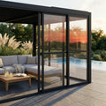 Laterale in policarbonato grigio scuro integrato in una pergola bioclimatica moderna, che filtra la calda luce del tramonto accanto a un'elegante area lounge esterna.