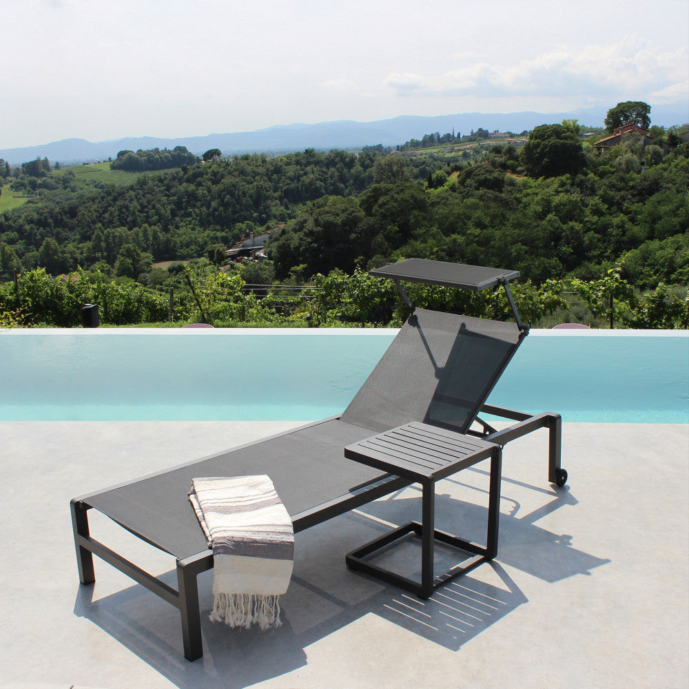 Lettino prendisole Madison di colore antracite con struttura in alluminio, posizionato a bordo piscina.