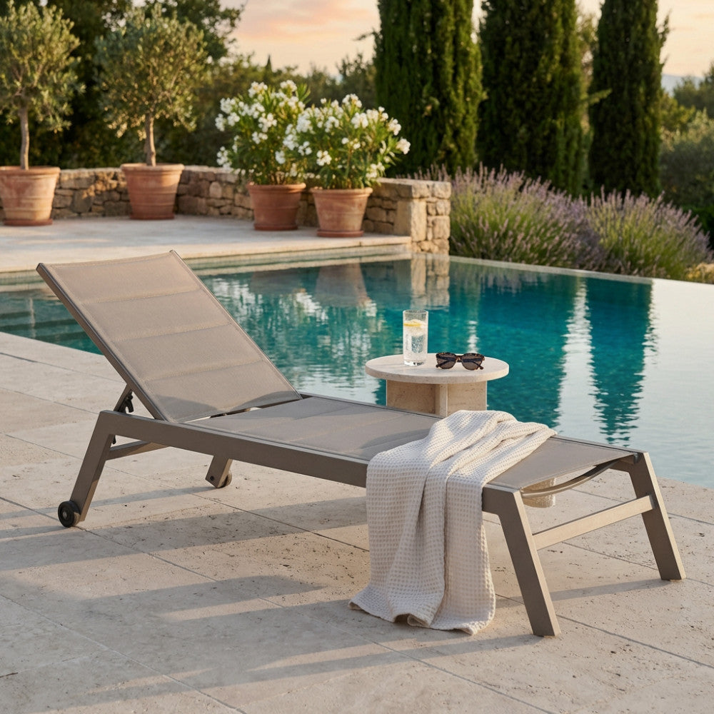 Lettino prendisole Formentera in alluminio e textilene taupe a bordo piscina.