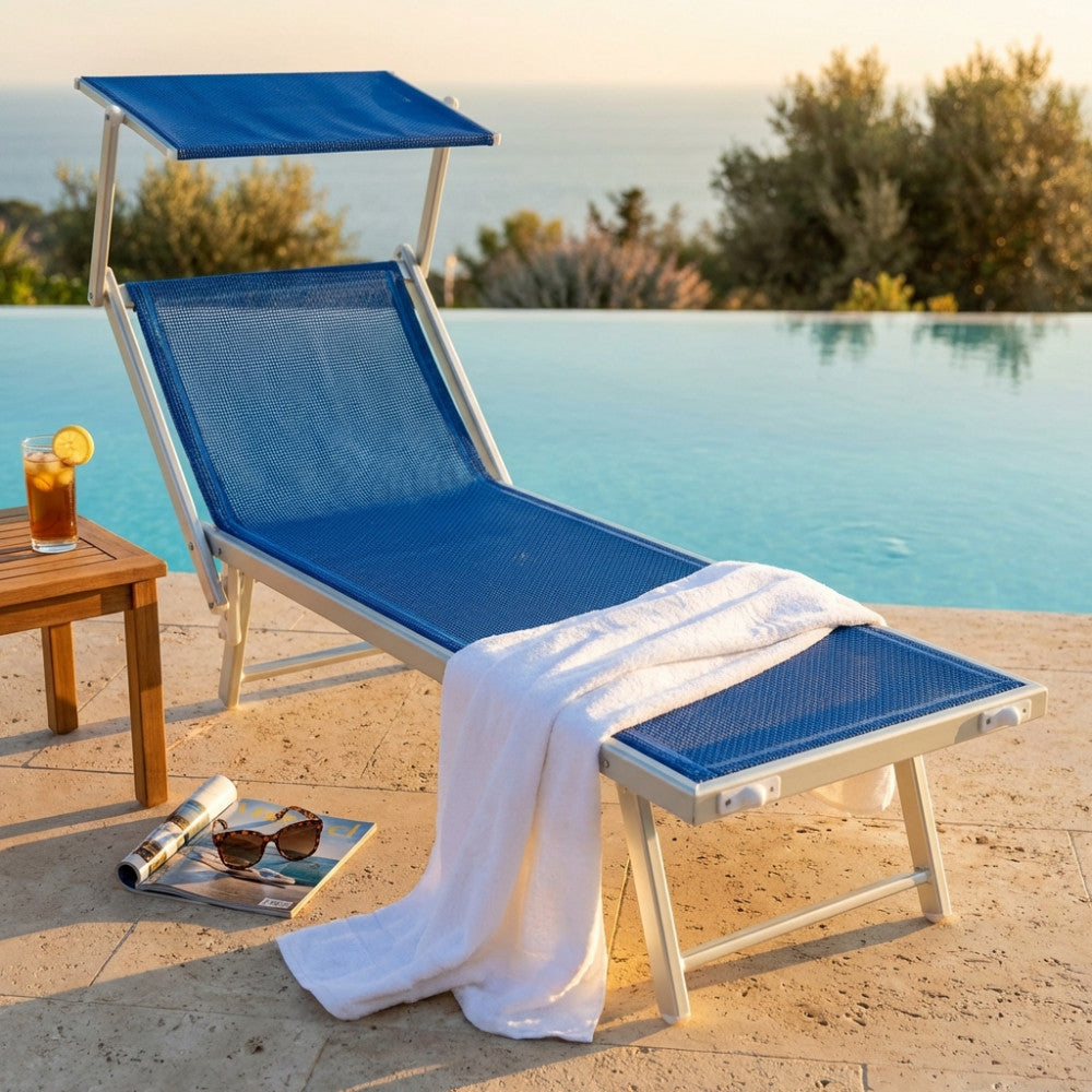 Lettino prendisole Otranto in alluminio e textilene blu a bordo piscina con asciugamano bianco.