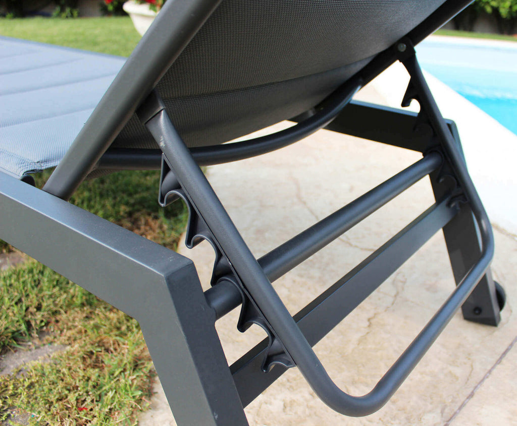 Lettino prendisole con struttura in alluminio verniciato antracite e rivestimento in textilene imbottito nero, posizionato in un ambiente esterno.