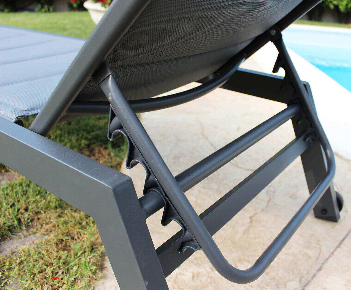 Lettino prendisole con struttura in alluminio verniciato antracite e rivestimento in textilene imbottito nero, posizionato in un ambiente esterno.