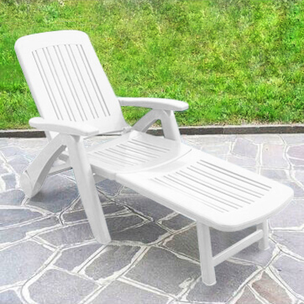 Lettino prendisole Cancun di colore bianco con ruote, realizzato in plastica, posizionato a bordo piscina.