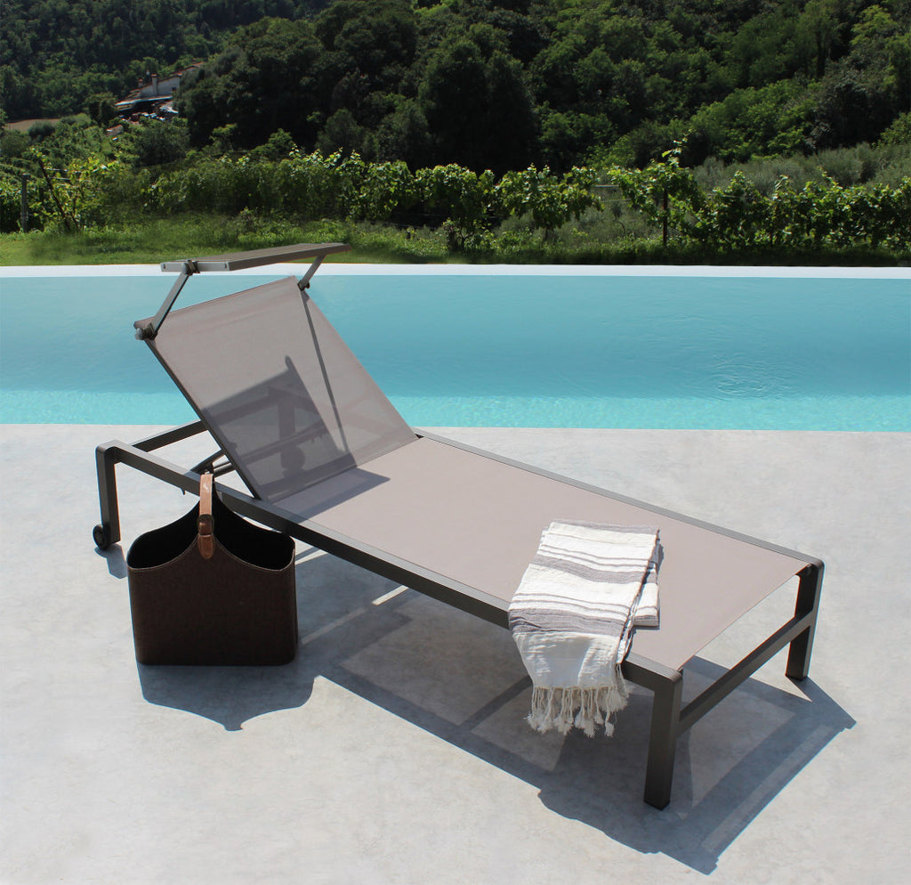 Lettino prendisole Madison di colore taupe con struttura in alluminio, posizionato a bordo piscina.