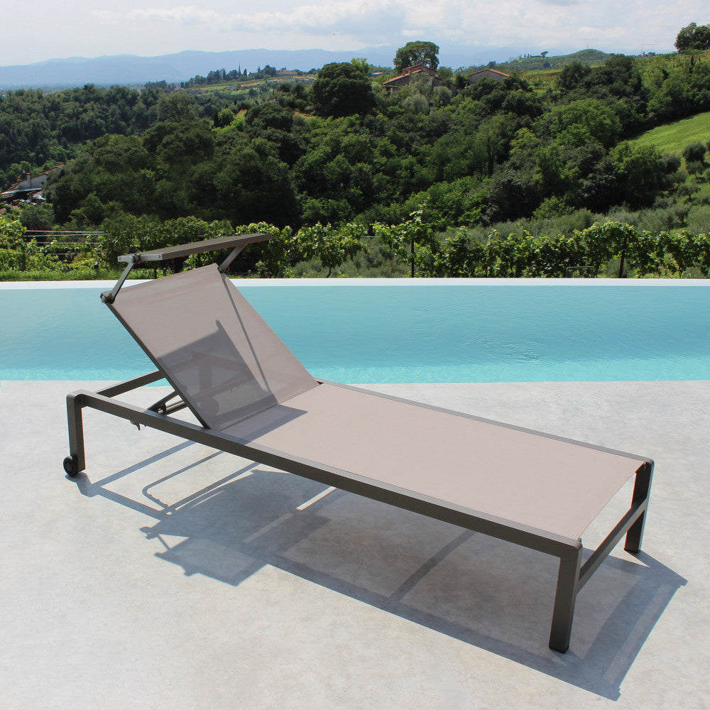 Lettino prendisole Madison di colore taupe con struttura in alluminio, posizionato a bordo piscina.