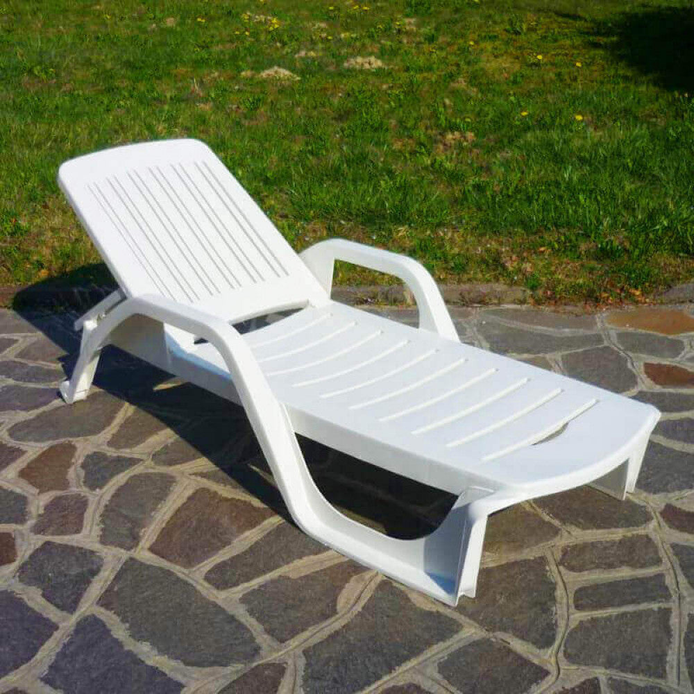 Lettino prendisole Zanzibar di colore bianco con ruote, realizzato in policarbonato, posizionato a bordo piscina