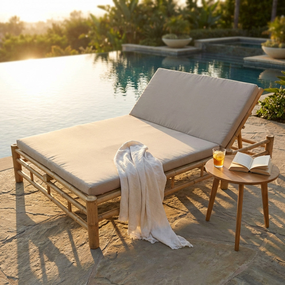 Daybed matrimoniale Affinity in bambù naturale con cuscino grigio chiaro a bordo piscina.