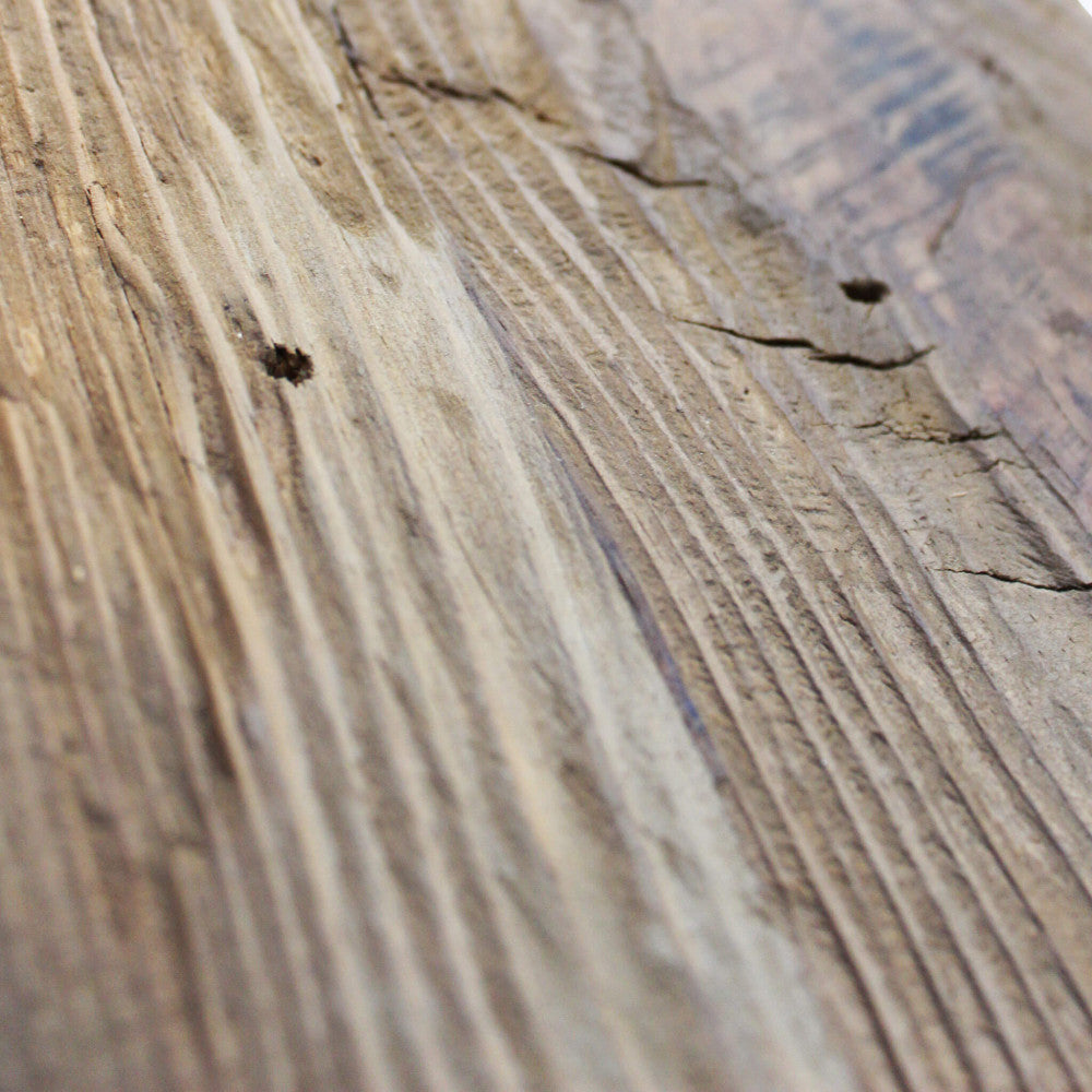 Macro fotografia della texture del pino riciclato, evidenziando venature profonde e segni del tempo.