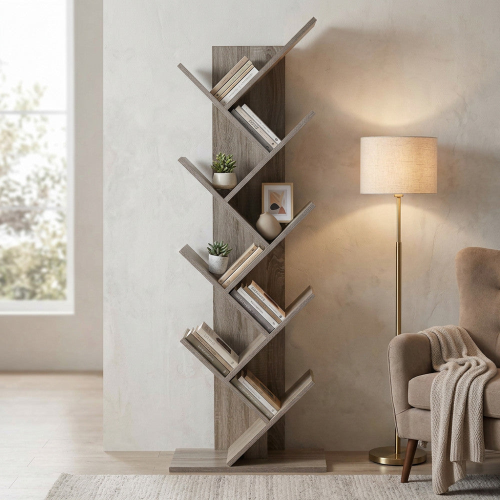 Vista angolare della libreria ARIANE marrone, decorata con piante e libri accanto a una poltrona elegante.
