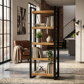 Libreria Alberic in legno di mango e metallo nero ambientata in un luminoso soggiorno dal design industriale.