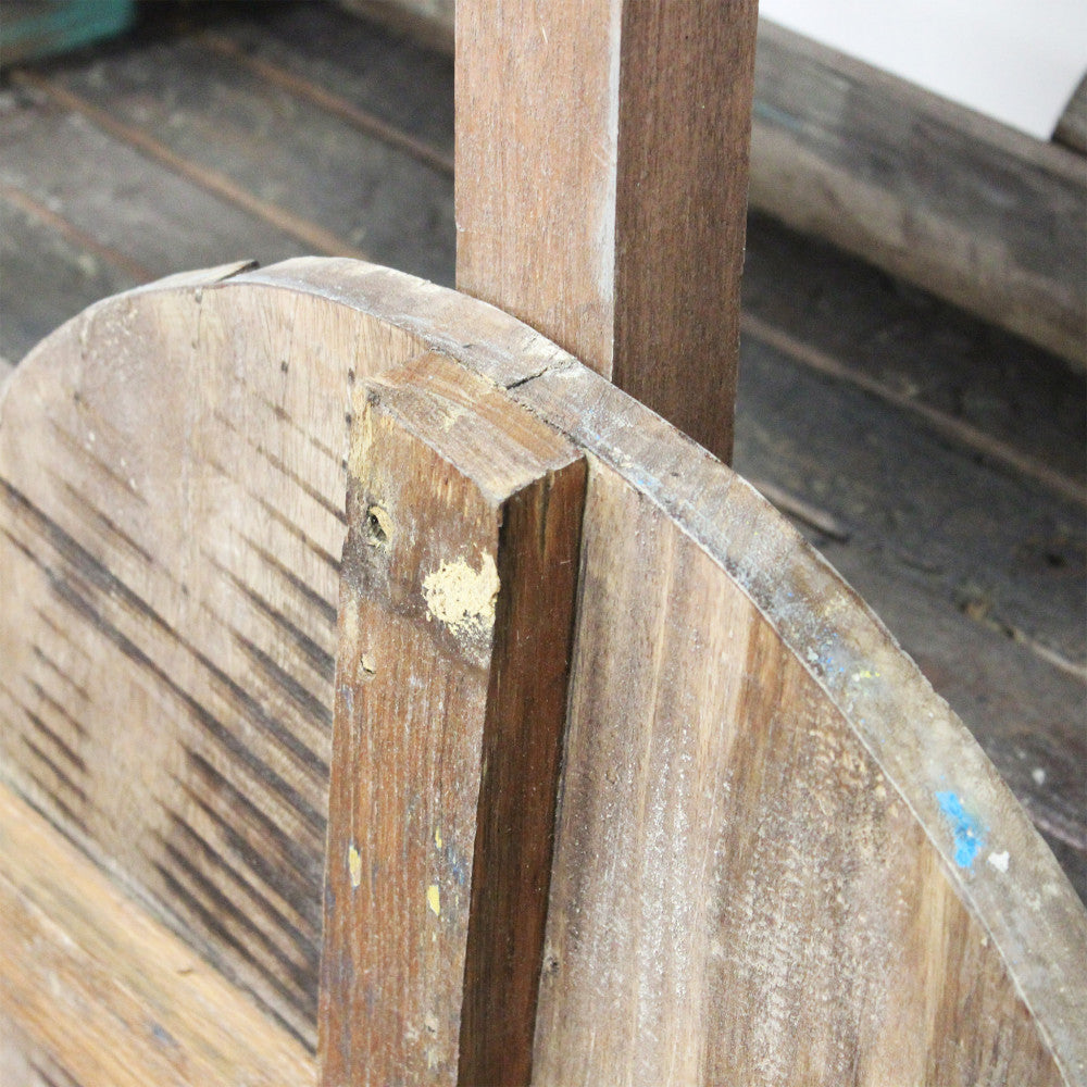 Dettaglio del sistema di fissaggio e della grande ruota in legno del carrello decorativo.