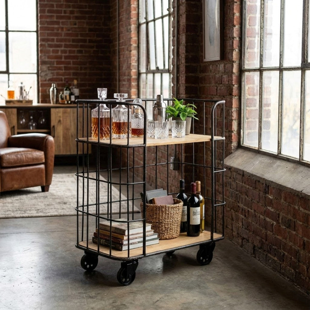 Carrello industriale in legno e metallo allestito come angolo bar con decanter in cristallo.