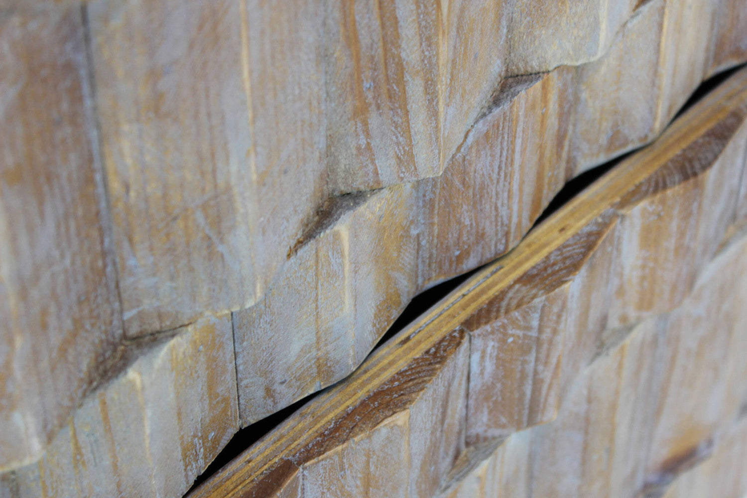 Dettaglio ravvicinato del profilo scolpito dei cassetti in legno della cassettiera Alwyn.