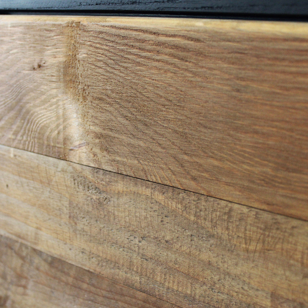 Primo piano delle venature naturali e della texture autentica del legno marrone del mobile ANSELM.