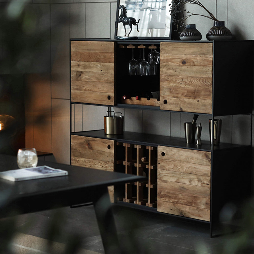 Atmosfera serale con la credenza bar Arden illuminata, che esalta i toni caldi del legno marrone.