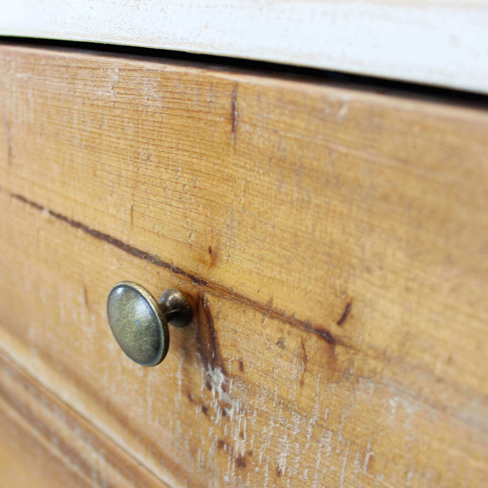 Dettaglio macro del cassetto in legno naturale della credenza Austen, mettendo in risalto le venature tattili e il pomello in metallo anticato.