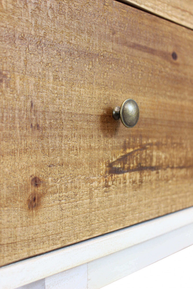 Dettaglio macro del pomello in metallo anticato e della texture effetto legno sul cassetto del Comò Barney.