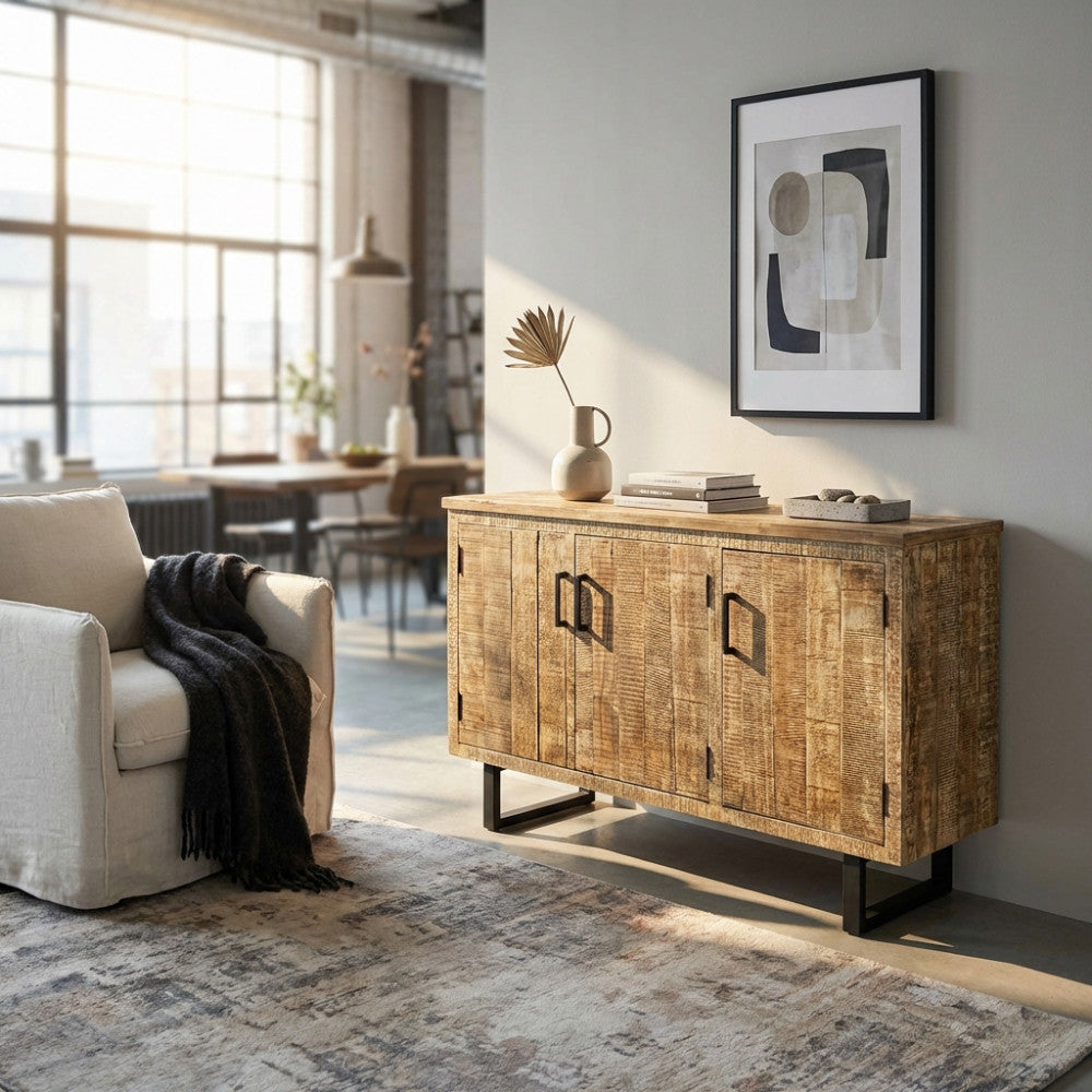 Credenza Benson in legno e metallo ambientata in un living luminoso con poltrona chiara.
