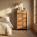 Vista frontale angolata della cassettiera in legno massello in una camera da letto illuminata dal sole.