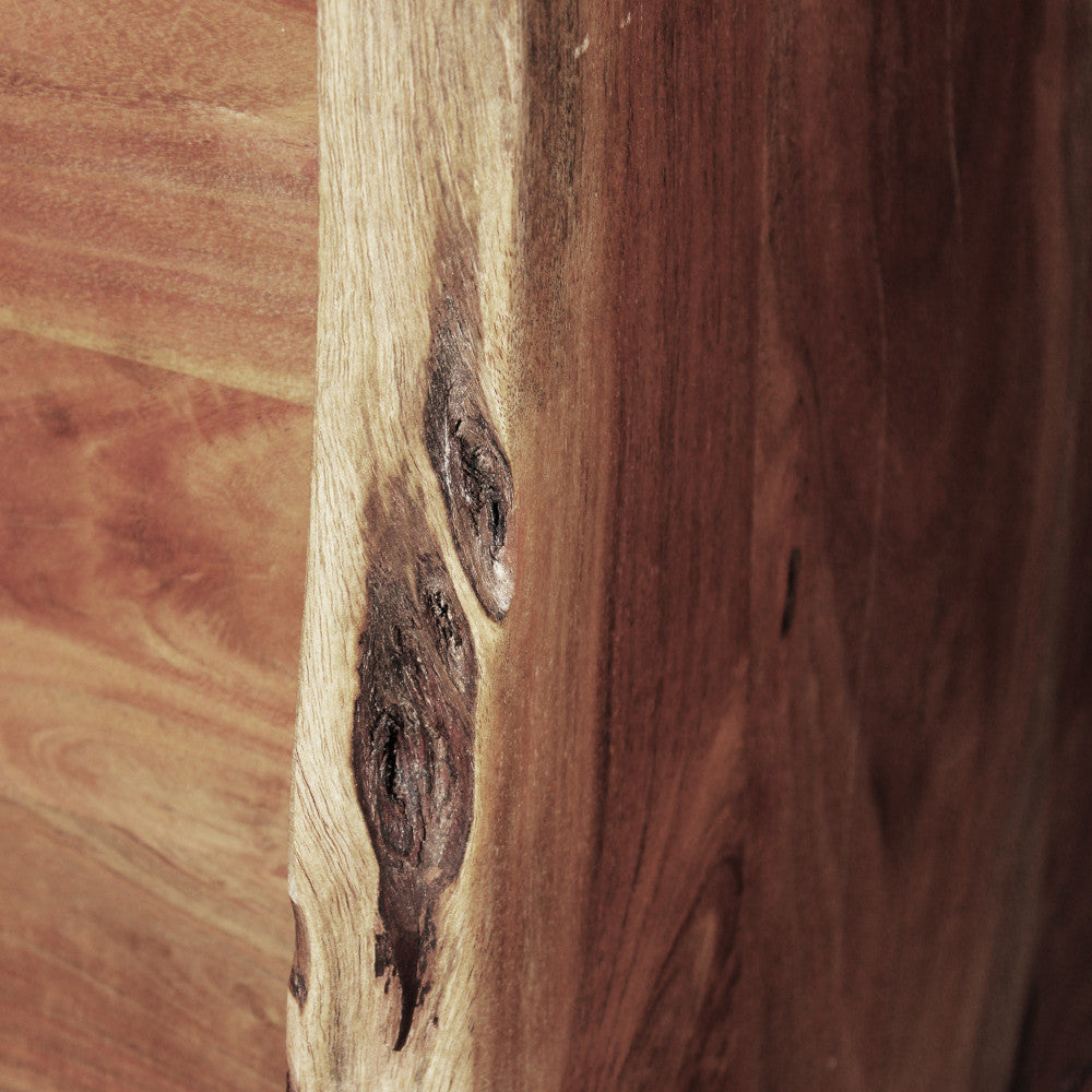 Macro dettaglio di un nodo naturale del legno sul pannello laterale dal bordo irregolare.
