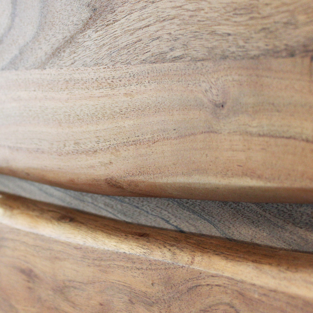 Macro dettaglio delle giunture orizzontali dei cassetti e della finitura liscia del legno.