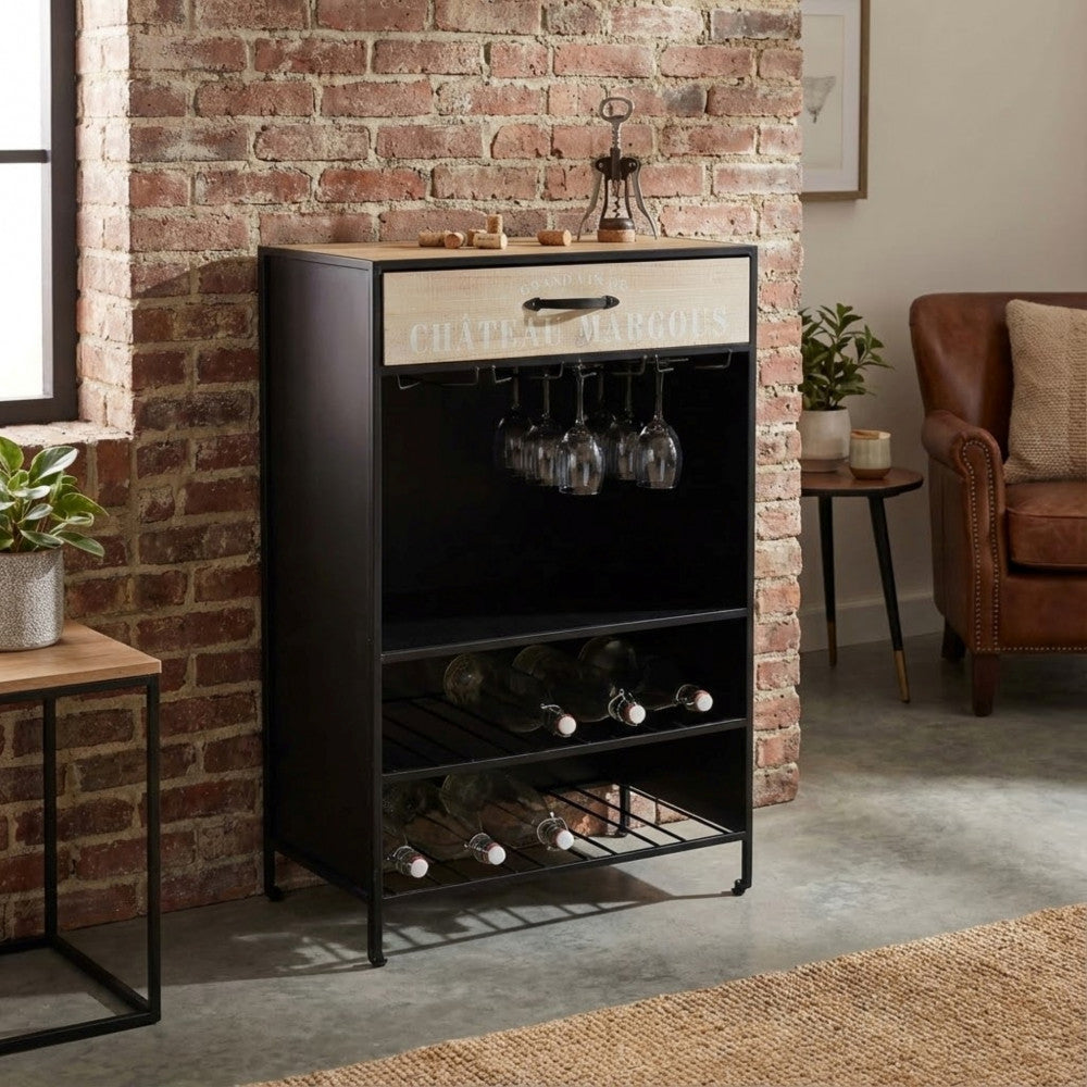 Mobile bar Bradford inserito in un contesto abitativo moderno, affiancato da una poltrona in pelle e piante decorative.