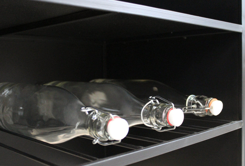 Dettaglio dei ripiani inferiori in metallo a doghe, progettati per ospitare in sicurezza le bottiglie di vino.