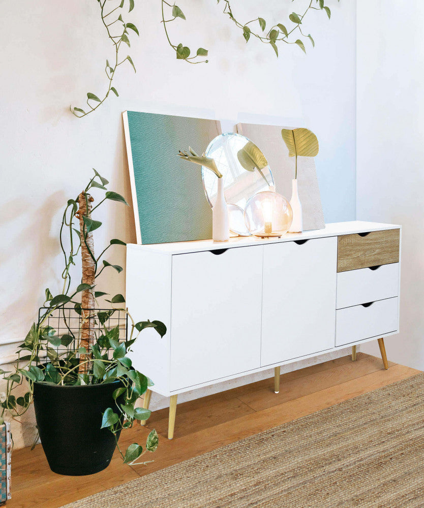 Styling d'interni con la credenza bianca decorata con specchi, piante e lampade di design.