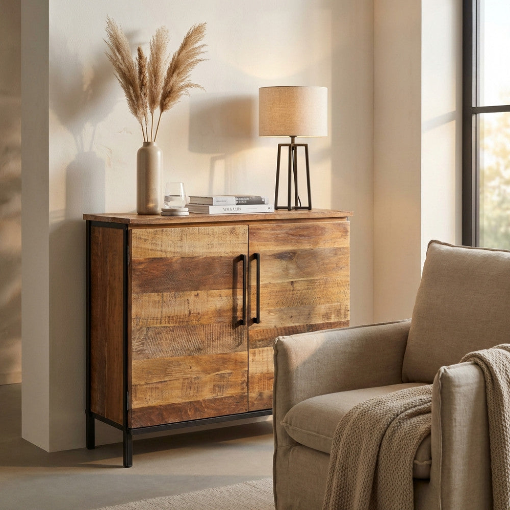 Dettaglio della credenza Braeden con lampada da tavolo e poltrona in lino neutro.
