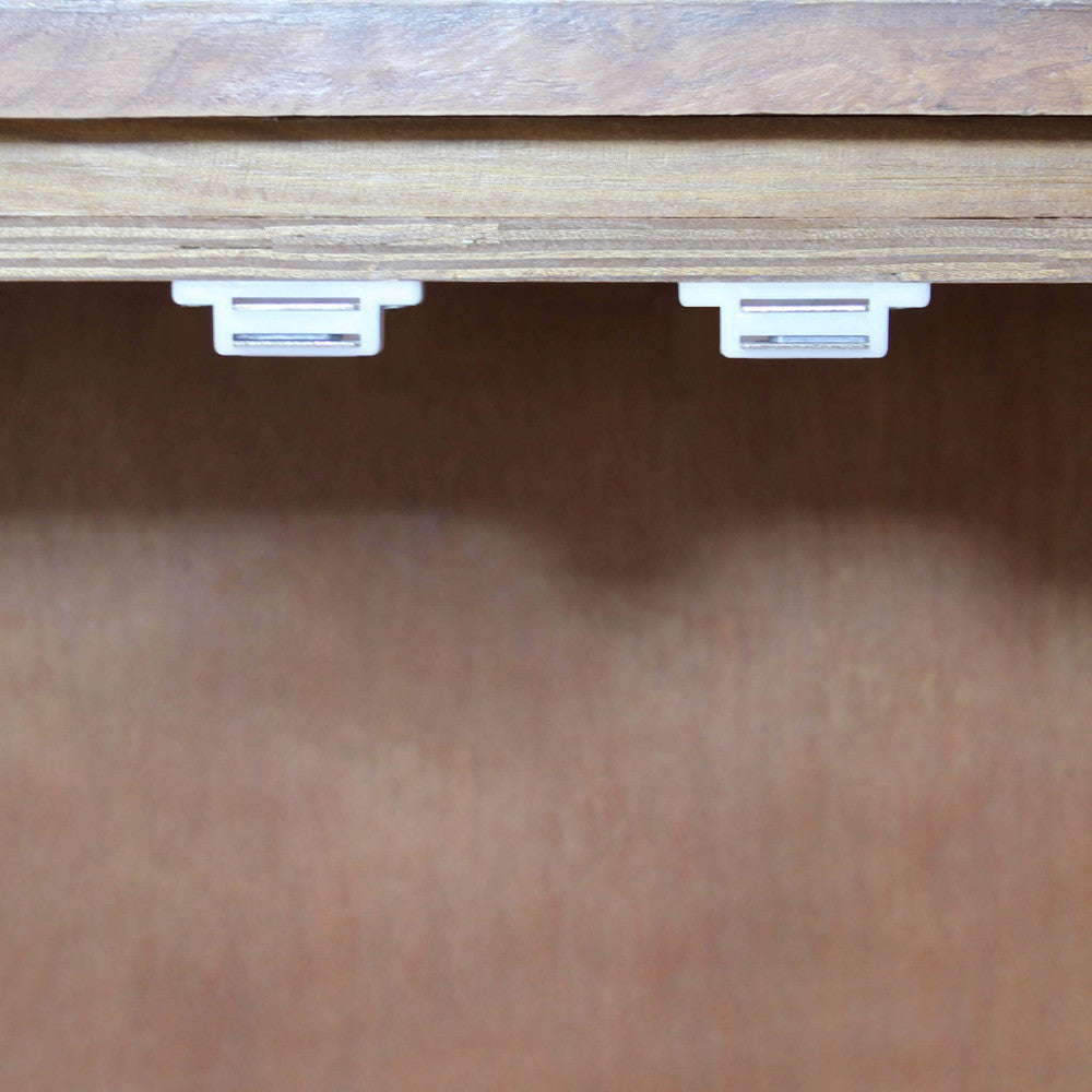 Dettaglio dei magneti di chiusura bianchi situati all'interno della credenza Braeden.