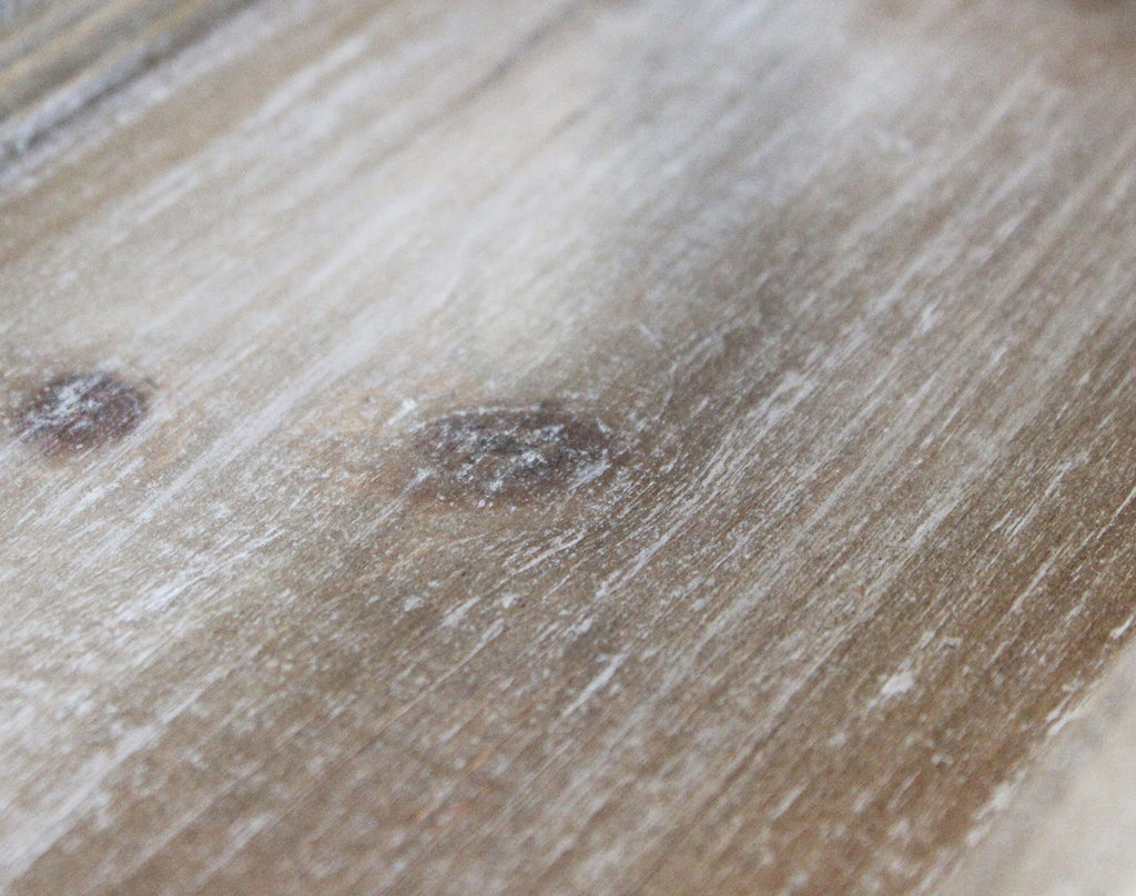 Dettaglio della texture superficiale della finitura in legno marrone anticato della libreria.