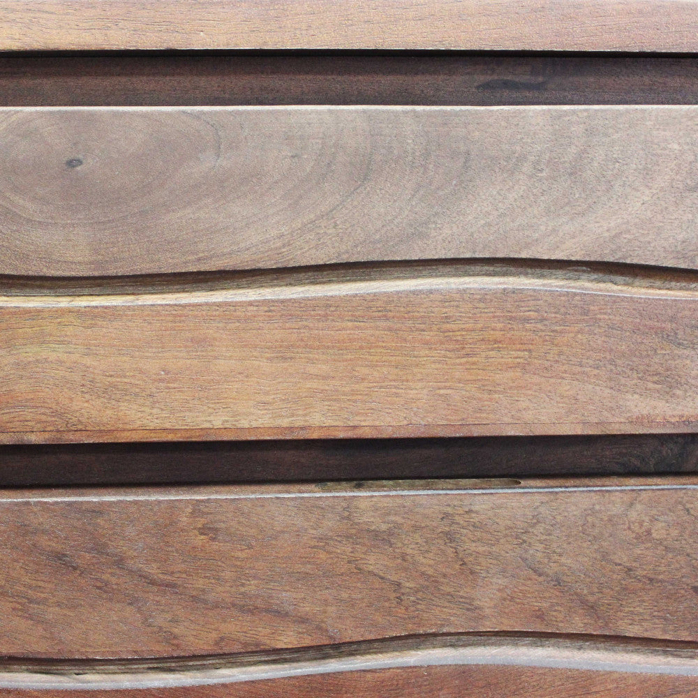 Dettaglio macro del design organico e ondulato sui frontali dei cassetti in massello di acacia, che rivela le texture naturali.