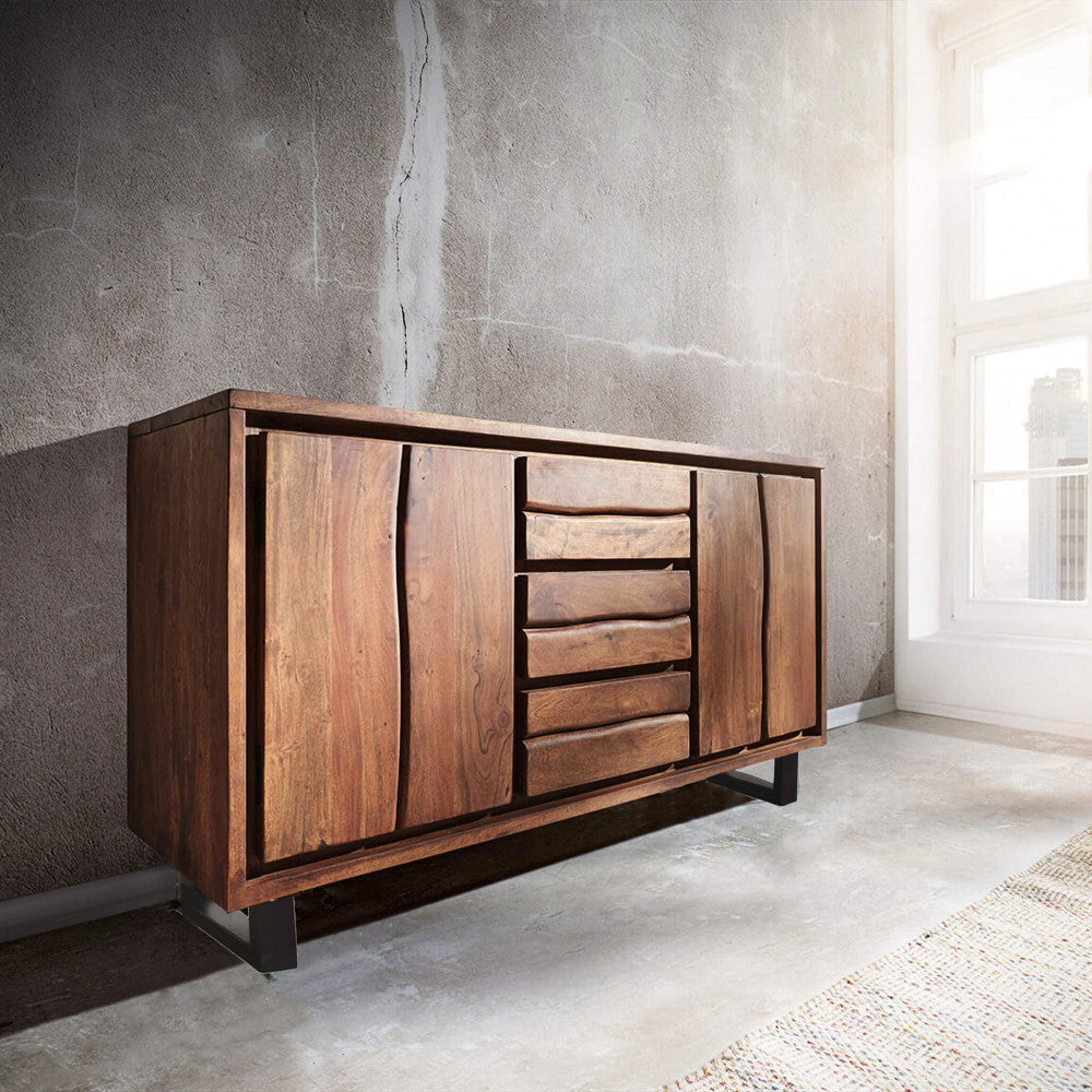 La credenza Brennan inserita in un loft in stile industriale con pareti in cemento, che ne esalta i caldi toni del legno.