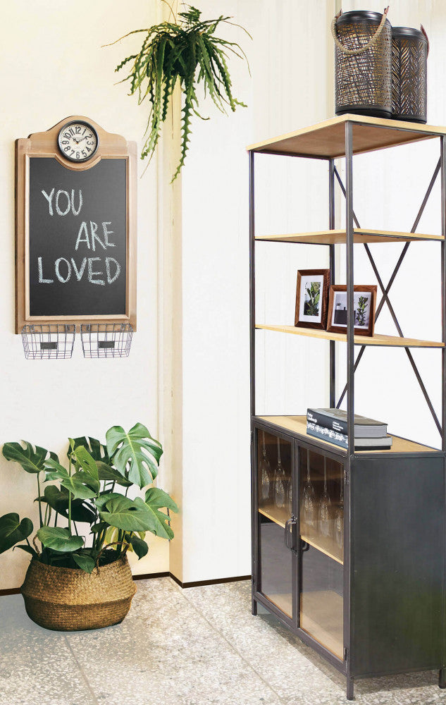 Ambientazione lifestyle della libreria BROCK utilizzata come mobile bar e libreria, affiancata da una pianta d'appartamento e decorazioni murali.