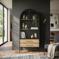 Vetrina Chadwick in acciaio antracite e legno marrone ambientata in un soggiorno moderno con luce naturale.