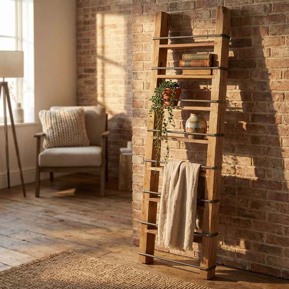 Libreria Charles in legno riciclato appoggiata a una parete in mattoni, illuminata dalla luce naturale.