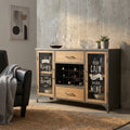 Credenza Christian in acciaio e legno ambientata in un living moderno con poltrona in pelle nera.